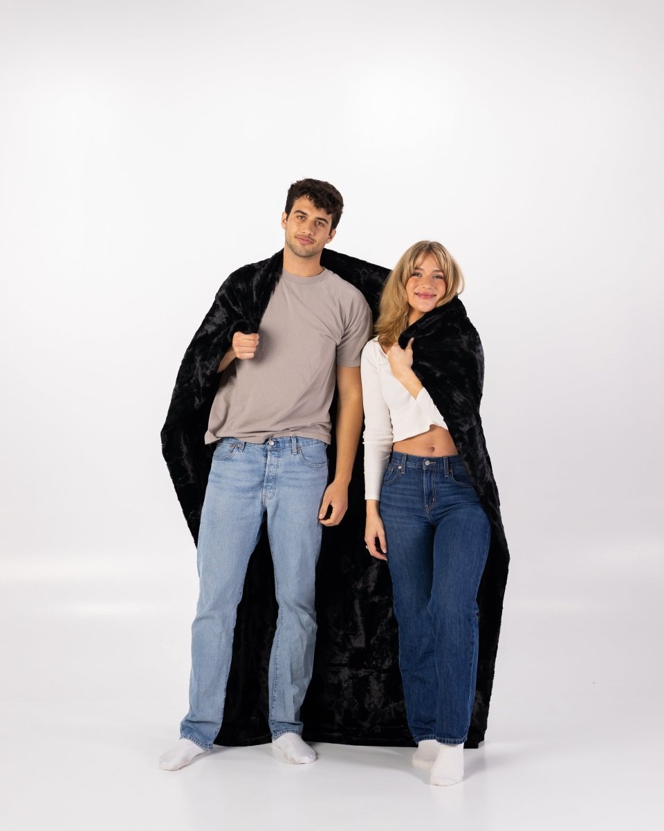 Black Bella Throw soft faux fur oversized blanket wrapped by couple