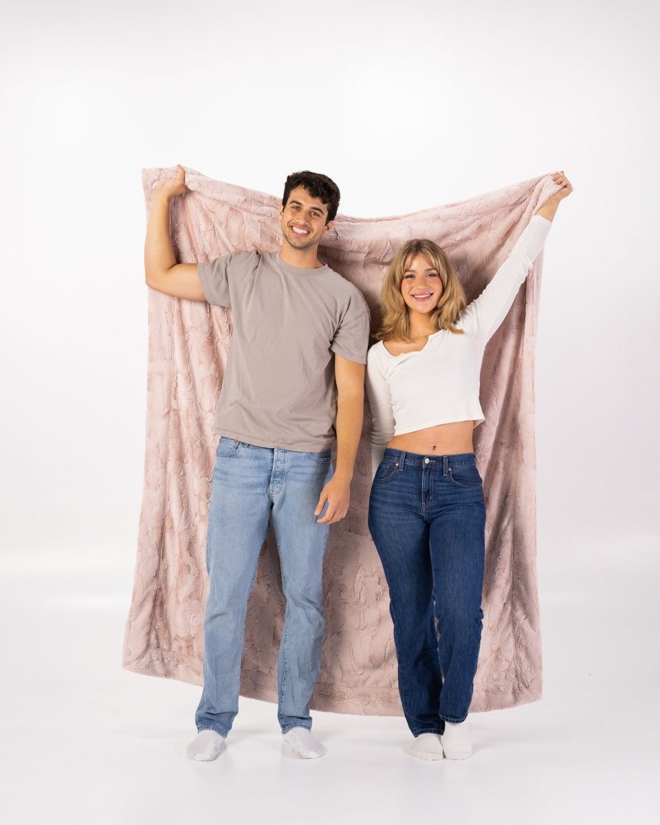 Blush Pink Bella Throw soft faux fur blanket held by a couple