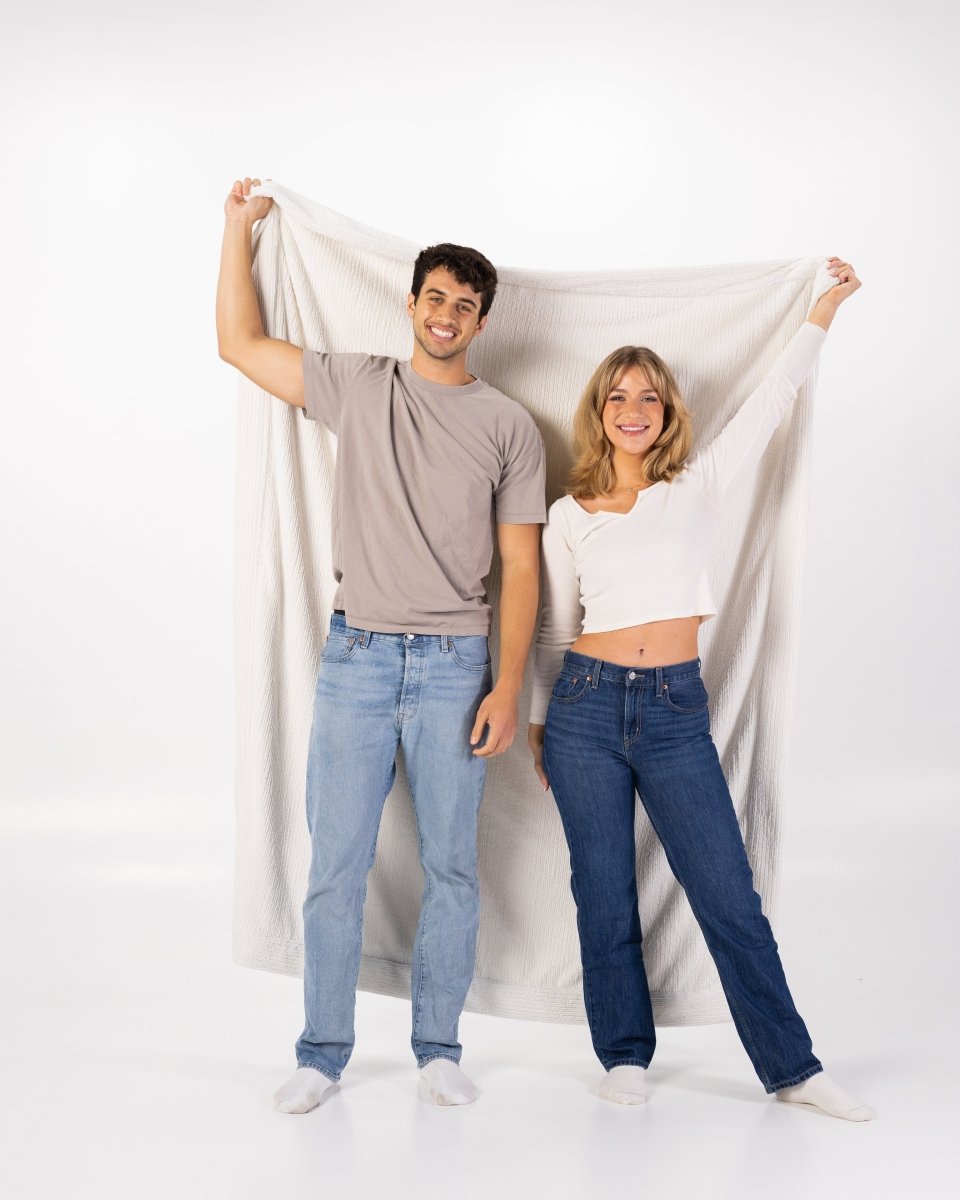 Ivory Weave White Cream Throw held by couple, oversized soft blanket.