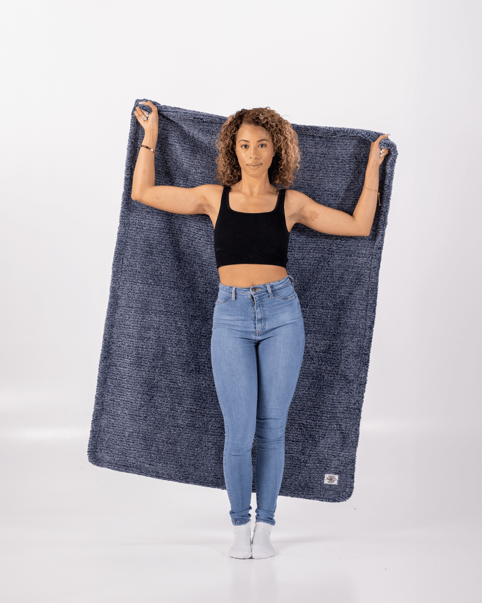 Navy Blue Weave Throw in ultra soft everyday blanket held up by woman