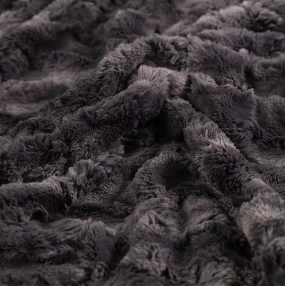 Woman snuggled in bed asleep peacefully with faux fur eye mask