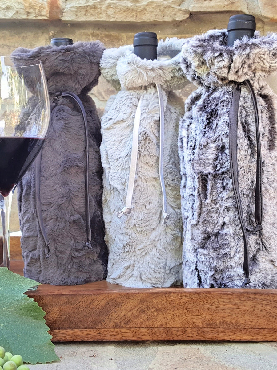 3 wine bottles each in a charcoal, silver, and birth Wine Sleeve