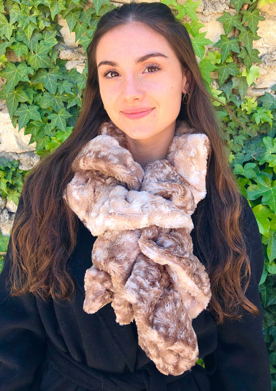 women keeping her Neck Warm with a scarf-like brown with soft white dots colored Neck Warmer which is the called the Fawn Neck Warmer