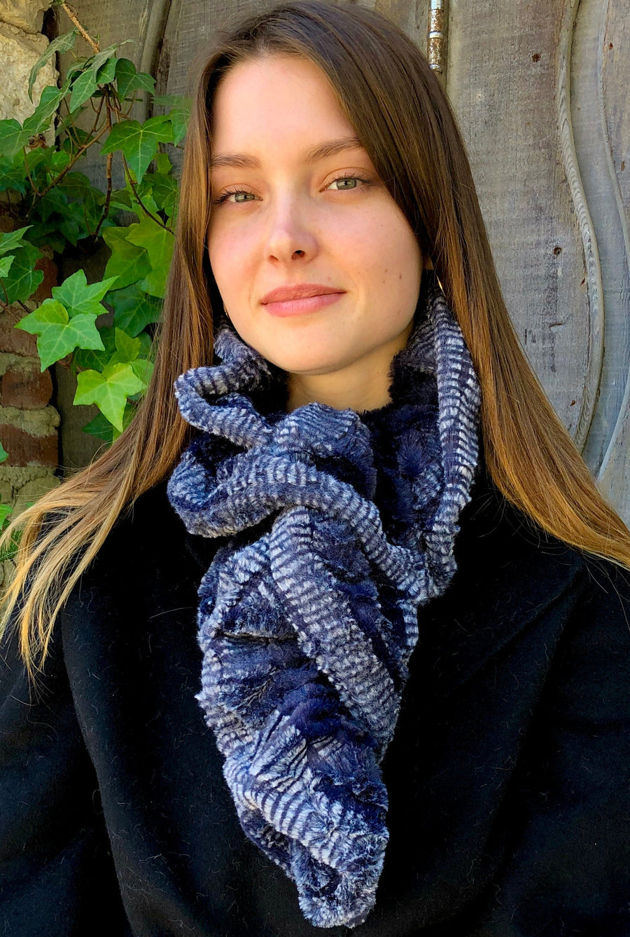 women keeping her Neck Warm with a scarf-like blue with soft white stripes on the edge colored Neck Warmer which is the called the Indigo Neck Warmer