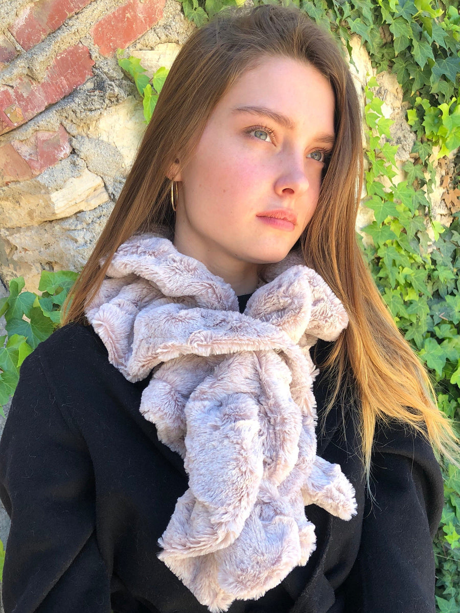 women keeping her Neck Warm with a scarf-like white with a slight touch of pink colored Neck Warmer which is the called the Quartz Neck Warmer