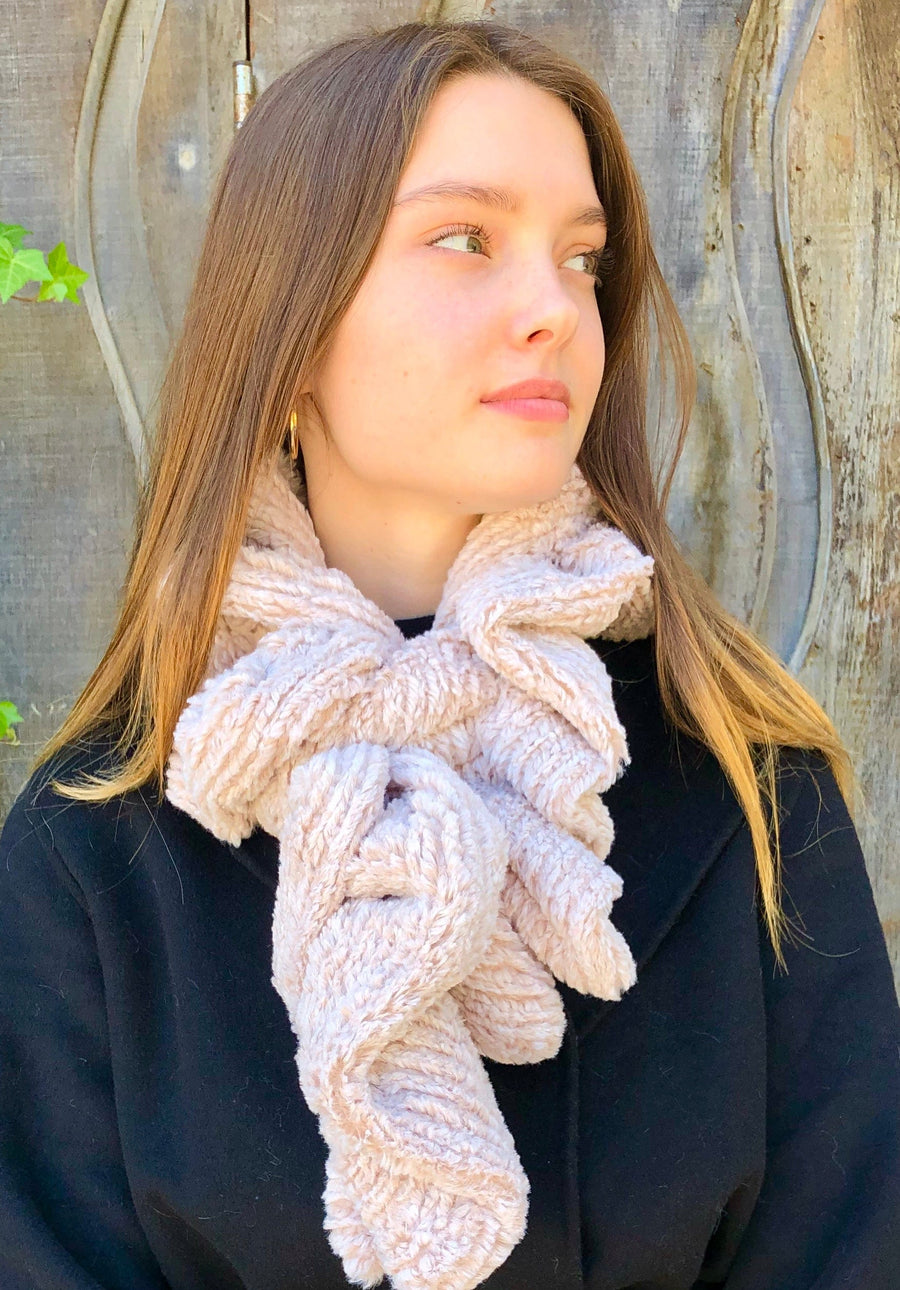 women keeping her Neck Warm with a scarf-like white with a hint of pink colored stripe textured Neck Warmer which is the called the Quartz Weave Neck Warmer