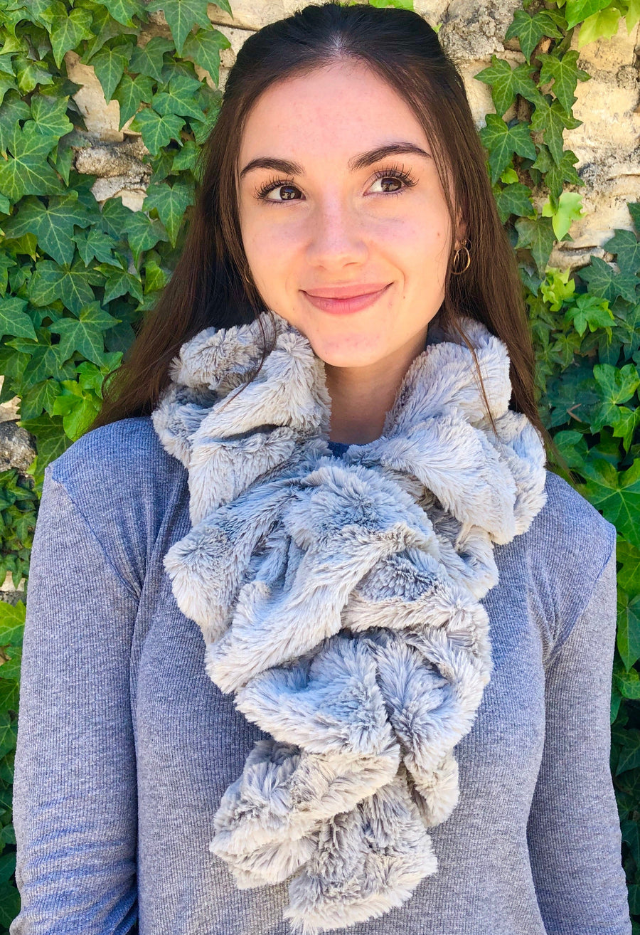 women keeping her Neck Warm with a scarf-like part white and part silver colored Neck Warmer which is the called the Silver Neck Warmer