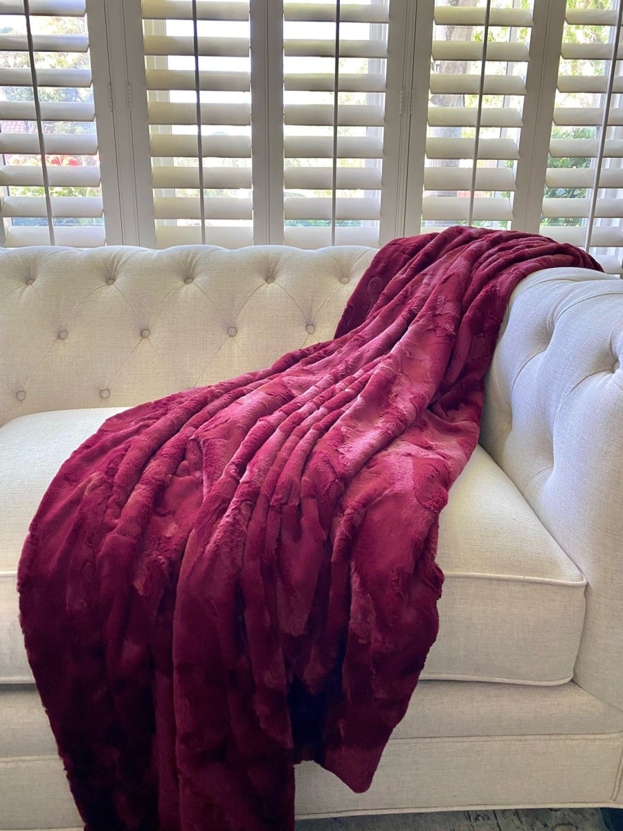 Crimson Red Throw soft faux fur blanket draped on living room couch in home