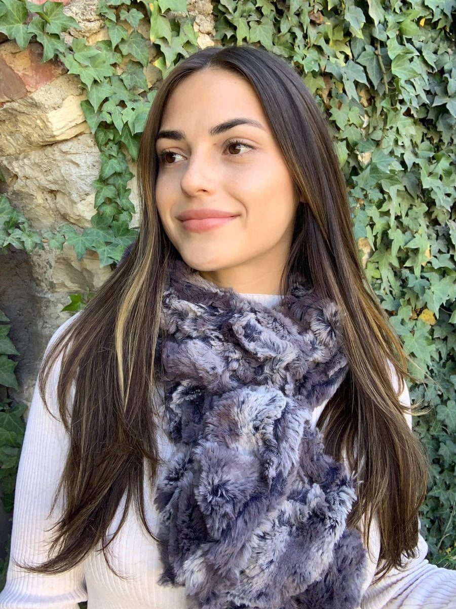 women keeping her Neck Warm with a scarf-like part dark brown-purple and part lavender with small streaks of dark purple colored Neck Warmer which is the called the Nine Iron Warmer