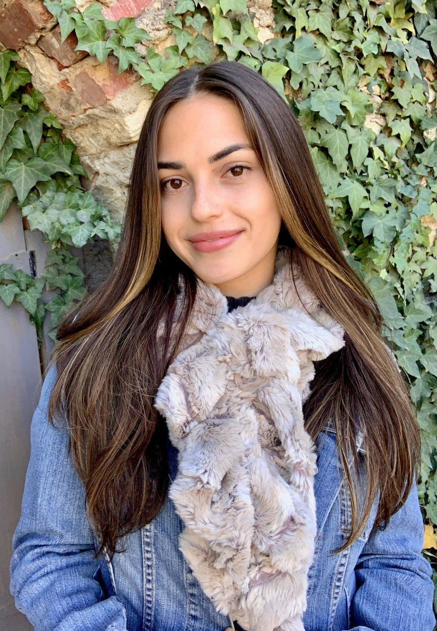 women keeping her Neck Warm with a scarf-like part light brown and part brown-red colored Neck Warmer which is the called the Sandshell Neck Warmer