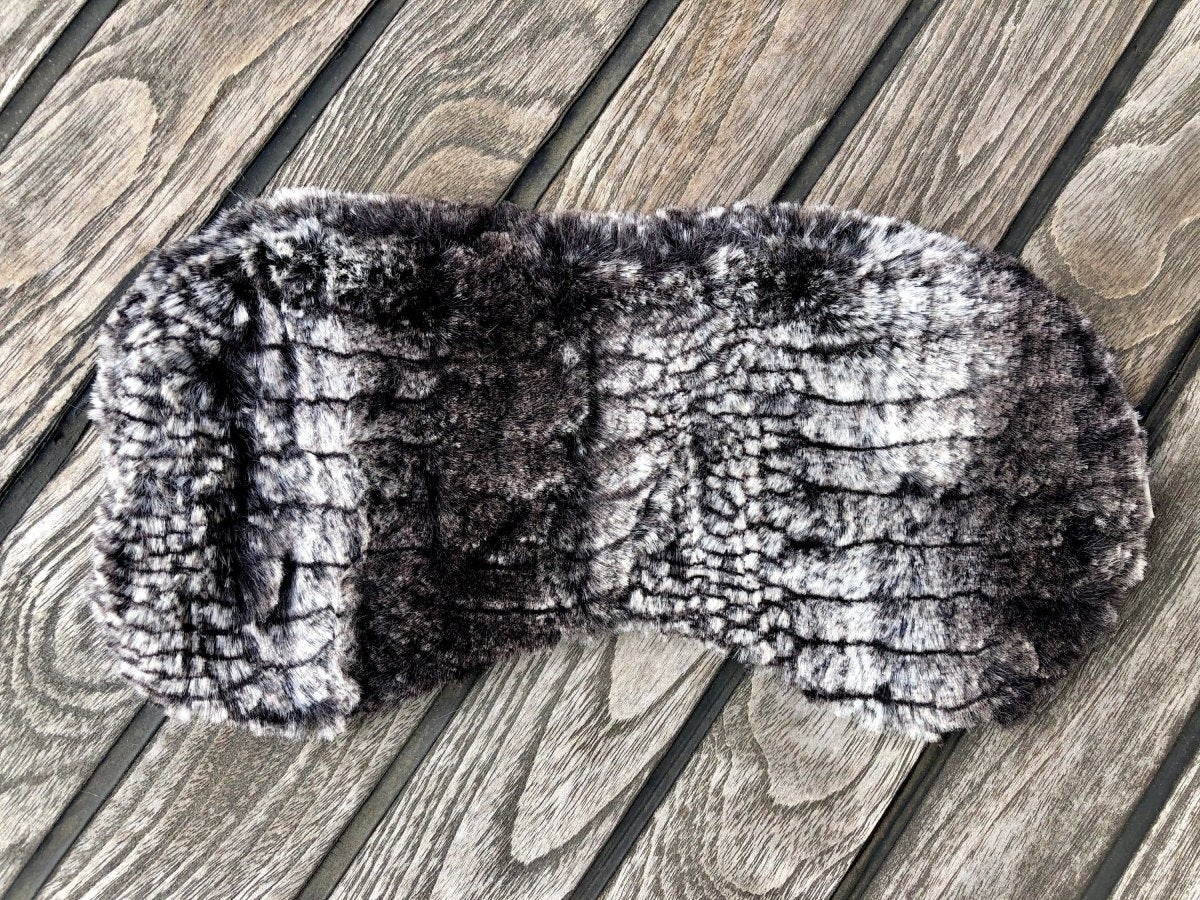 Woman snuggled in bed asleep peacefully with faux fur eye mask