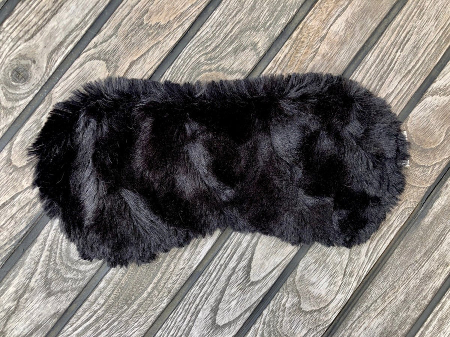 Woman snuggled in bed asleep peacefully with faux fur eye mask